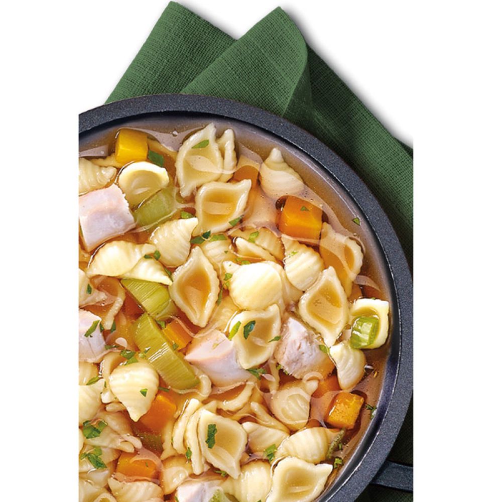 Hühnernudeltopf in Pfanne auf grüner Serviette