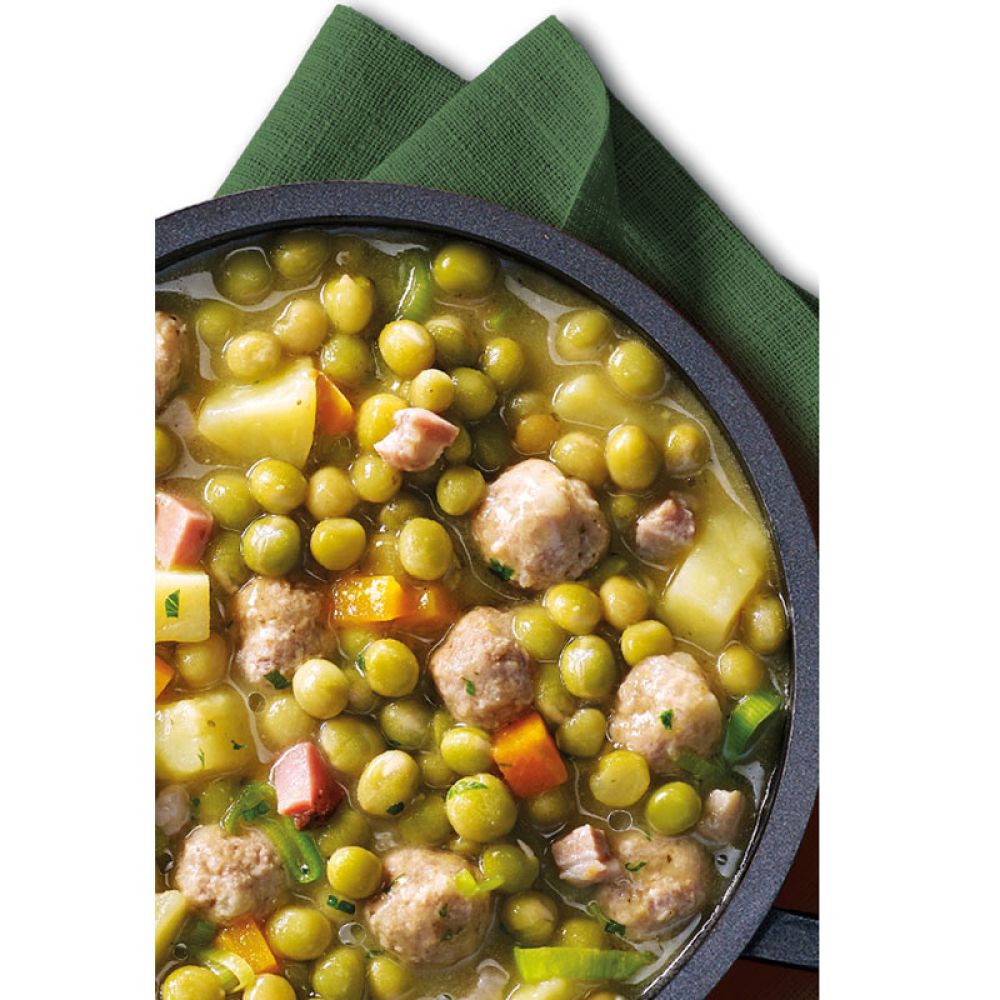 Erbseneintopf in Pfanne auf grüner Serviette