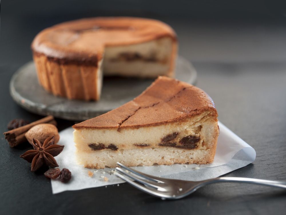 Kuchen angeschnitten, Stück steht davor, dekoriert mit Anis, Muskat, Zimtstange